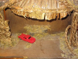 Nativity Invasion: Red toy truck in a manger