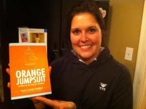 Kristen Gilles holding a copy of "Orange Jumpsuit: Letters to the God of Freedom" by Tara-Leigh Cobble