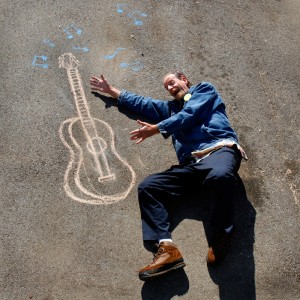 Homeless man "playing" image of a guitar written in chalk - part of Sojourn Church's "In 3 Years" project (sojournvisualarts.com)